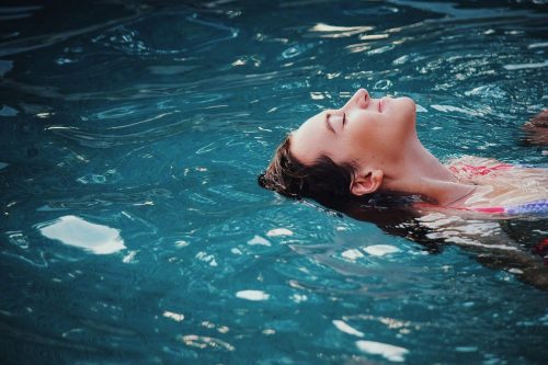 woman enjoying soaking in the blue water